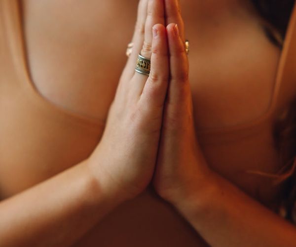Close-up of hands in a mindful gesture during a yoga practice.